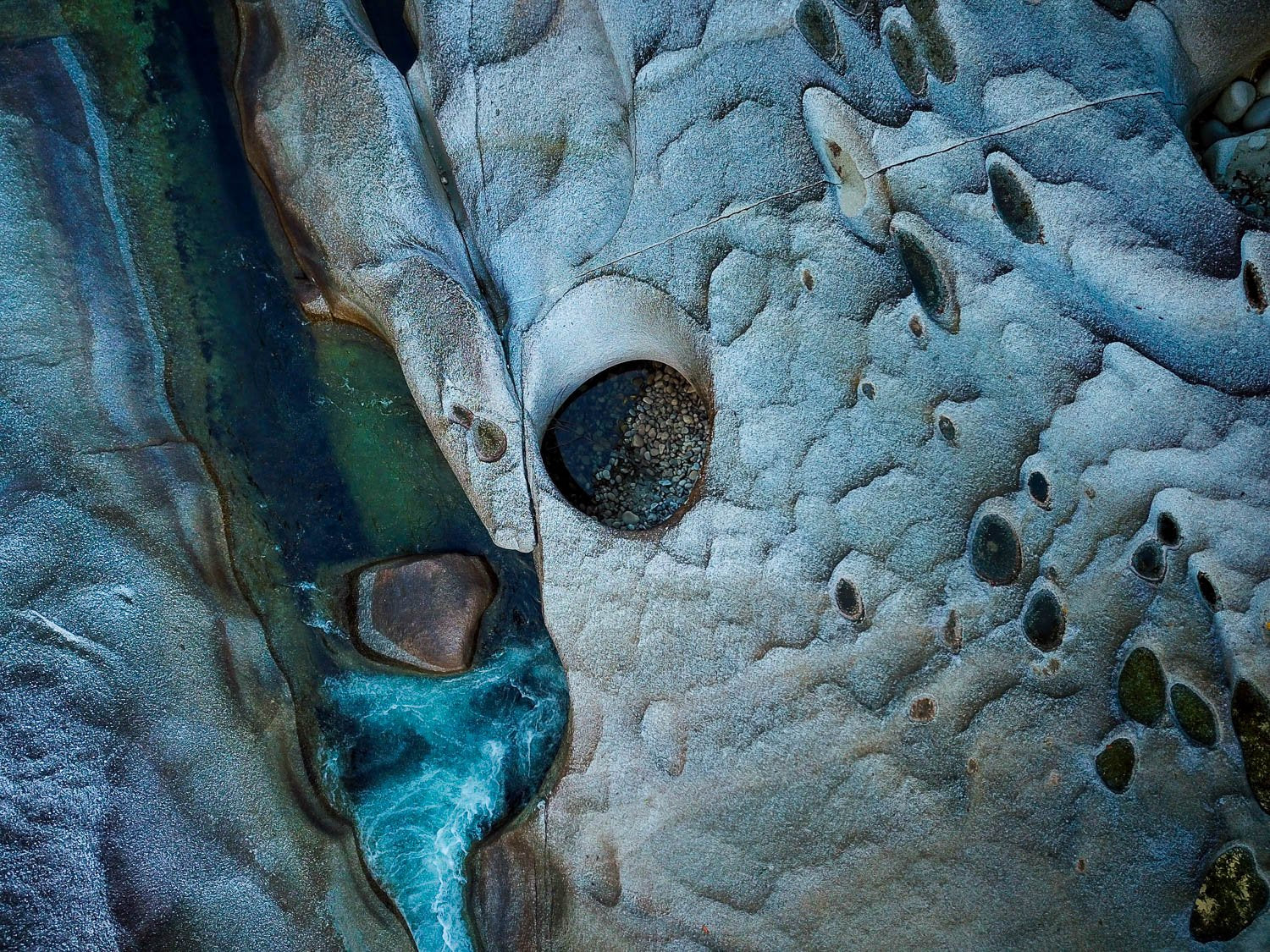 A weird texture of giant boulders having smoky and aqua colors, with some cracking texture on the surface, Babinda Boulders from above, Far North Queensland 