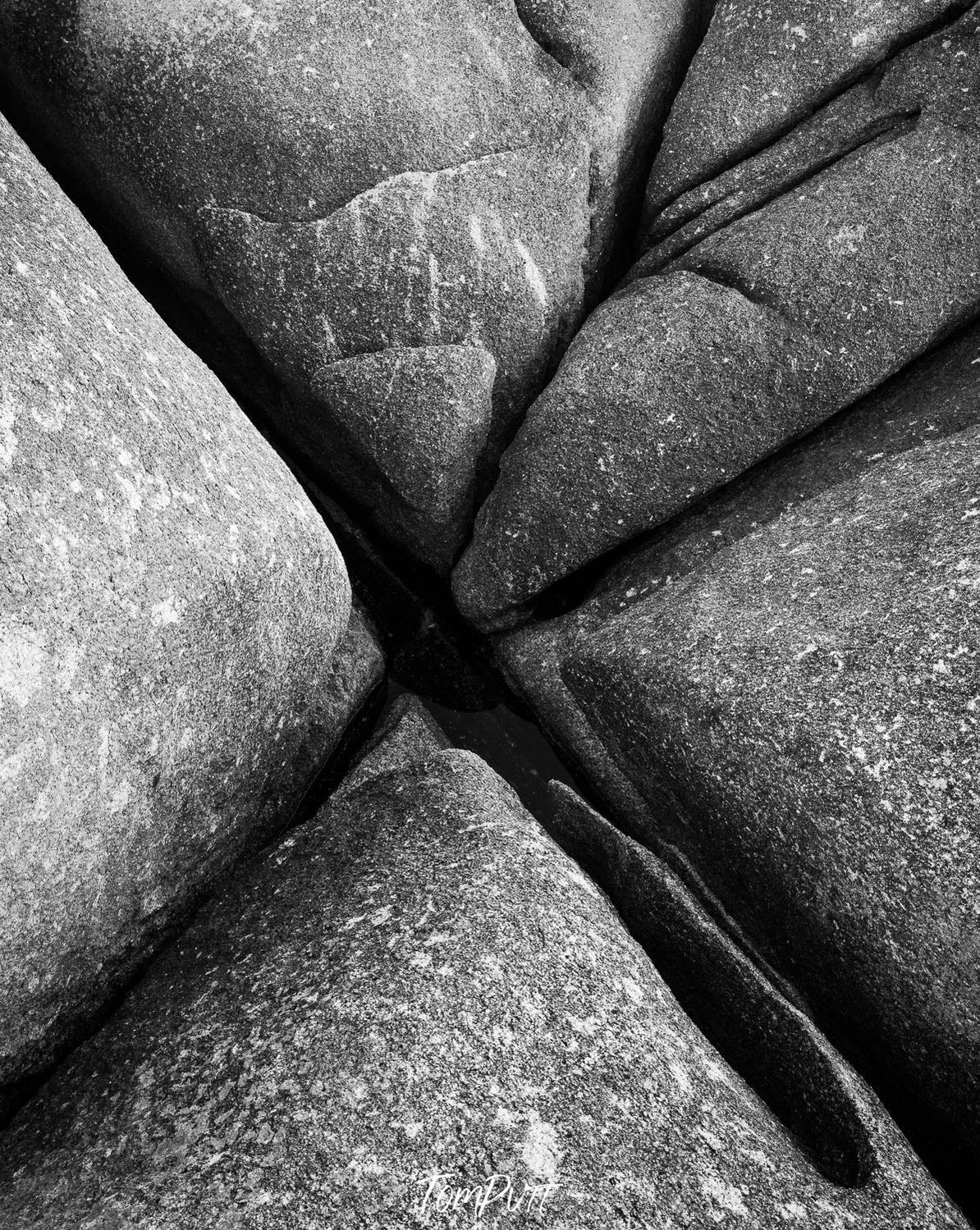 Parallel greyish-colored great boulders with some space in between, and some cracks in the topmost quadrant, Bay of Fires rocks grooves