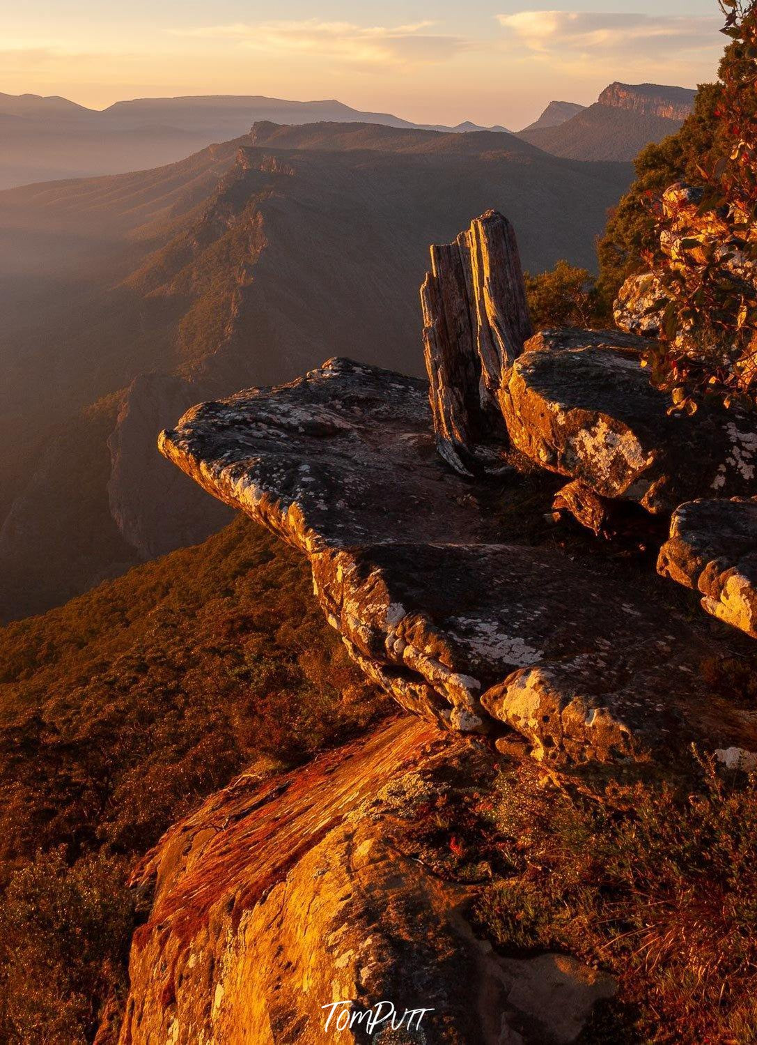 A close-up view of Giant Mountain stones on a high area with a huge grassy mound below them, and some other mountains and rocks in the background, Boroka Dawn - The Grampians, VIC