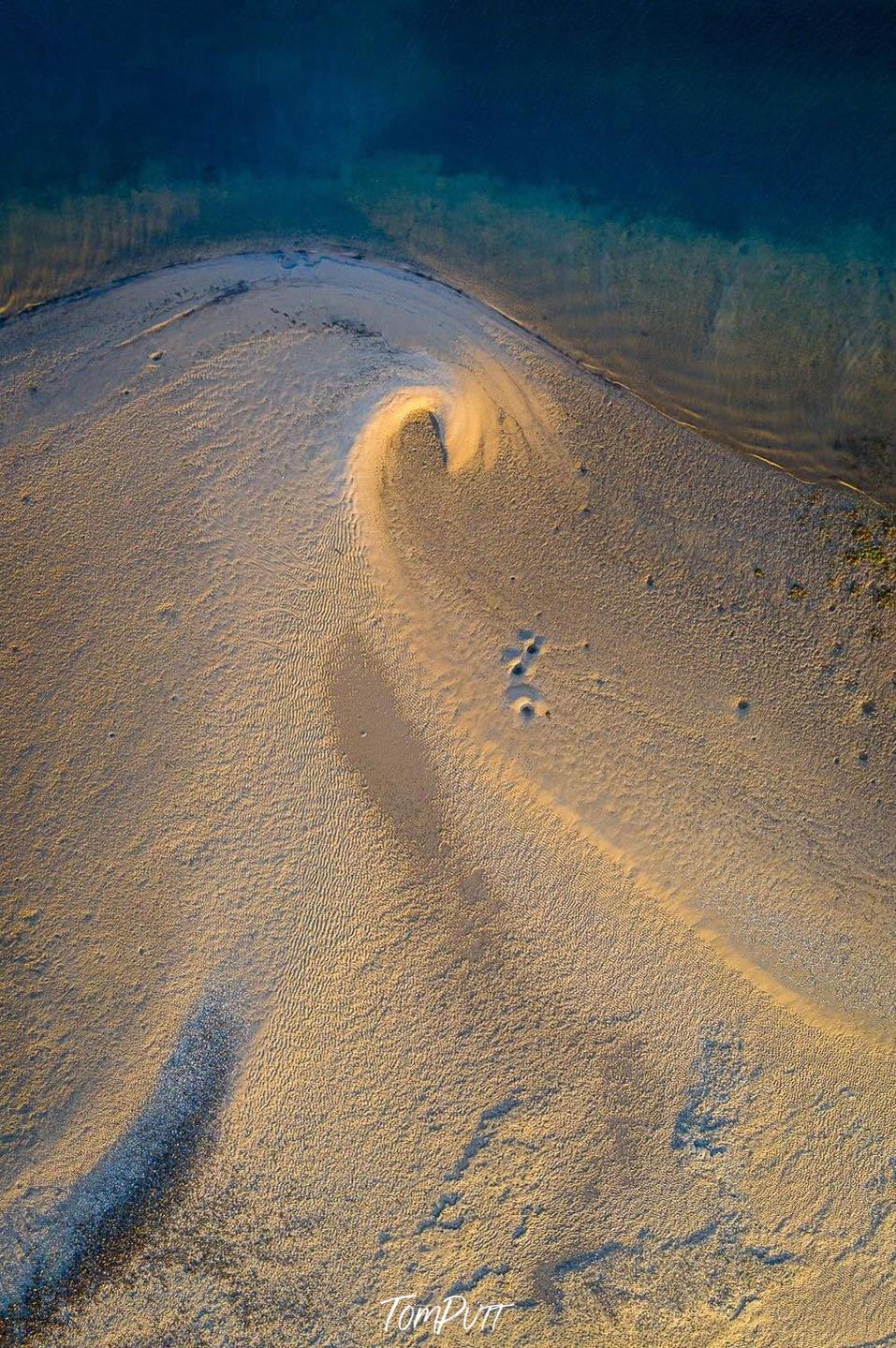 A heavy wave of the soil in a desert-like area with a little picture of green-watered sea connecting with it, Breaking Wave