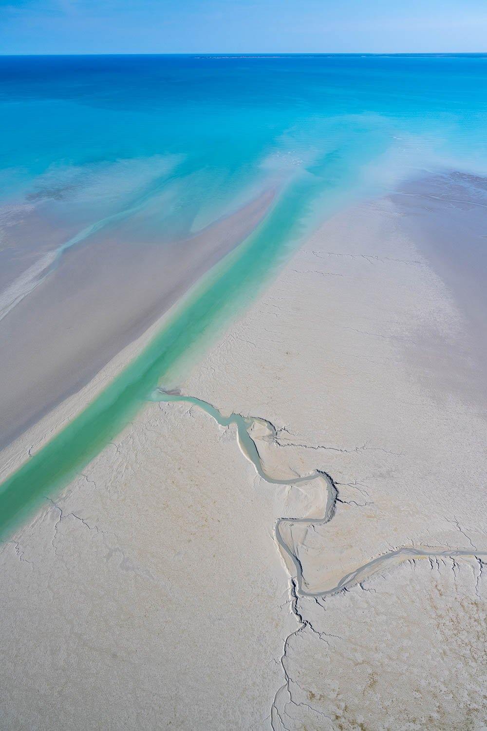 A shiny effect of blue ocean connecting with the land, green thick line water flowing liquid with some cracks on the land, Broome #7