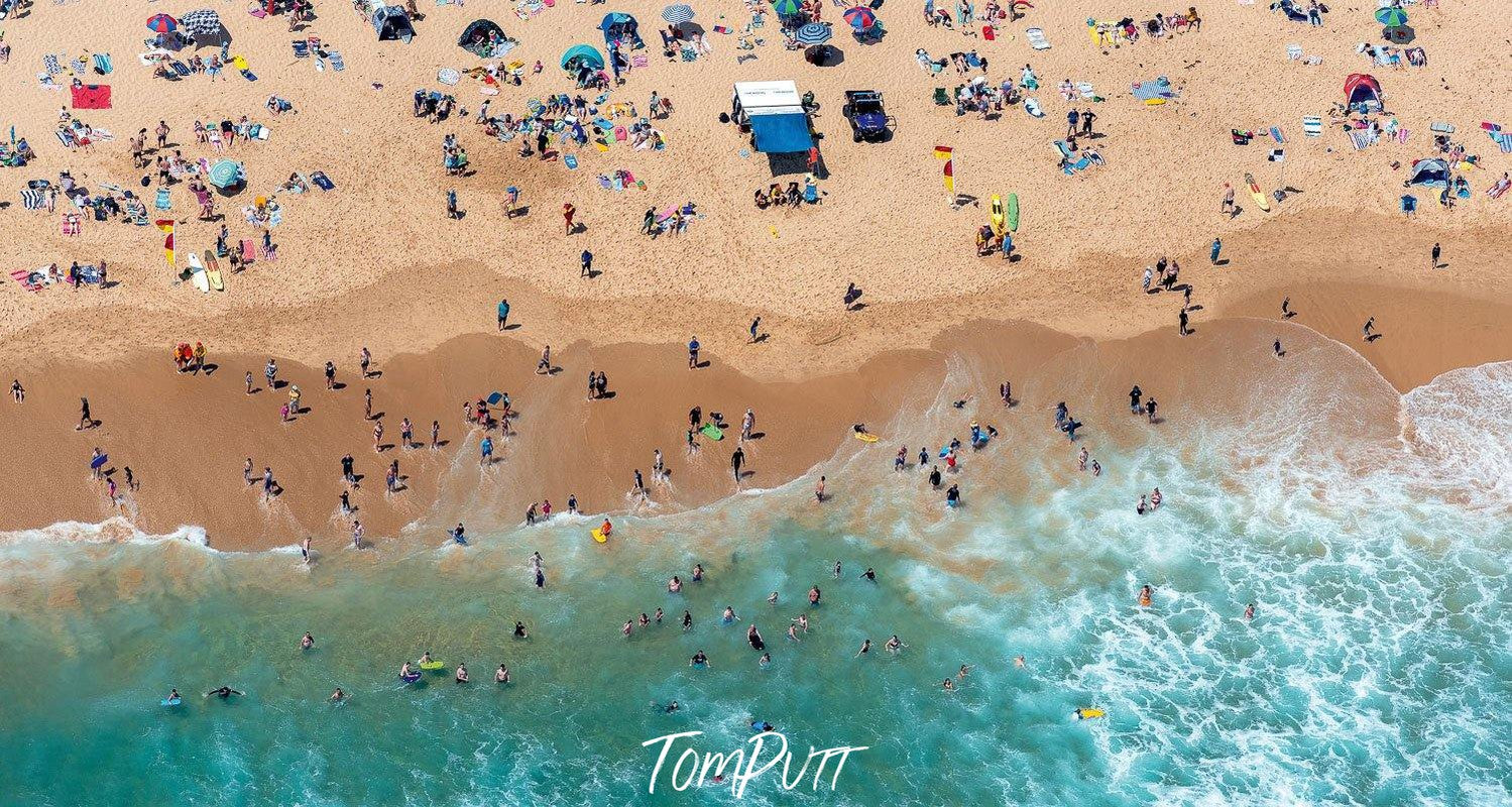 An aerial view of crystal clear water at the seashore with a lot of people in the water and on the sand, Cooling Off, Gunnamatta - Mornington Peninsula Victoria