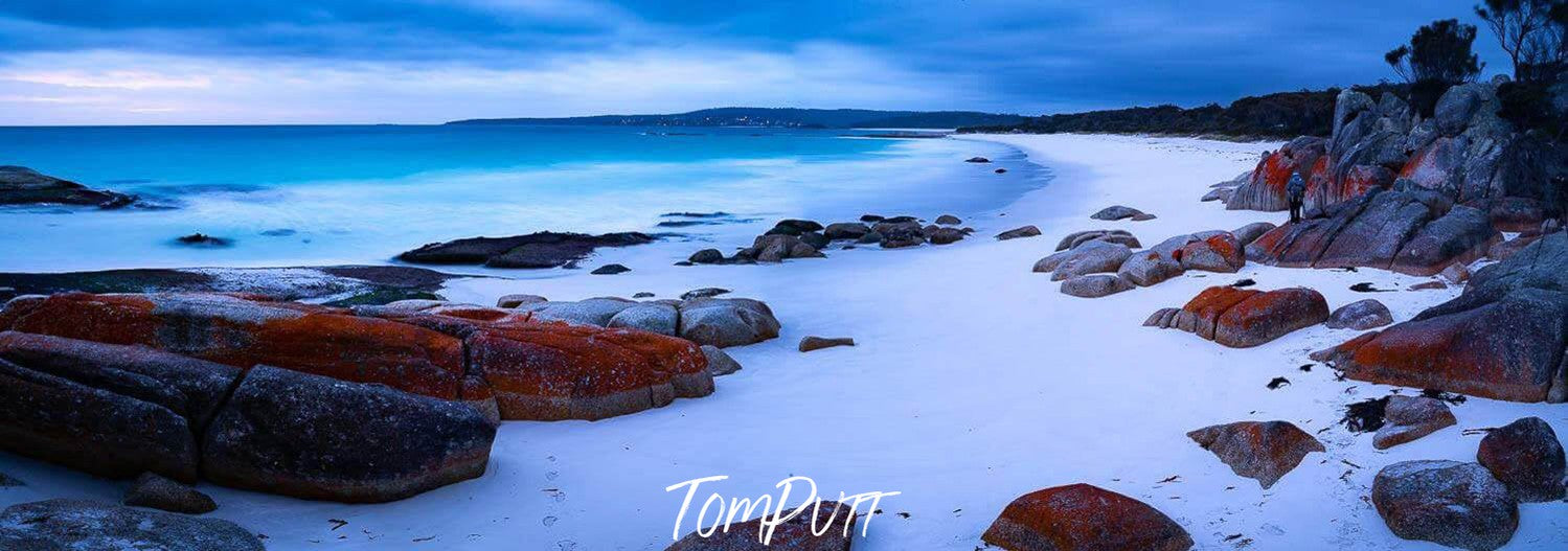 A beautiful landscape dim light view of a seashore with white powder-like sand and some random shaped stones with Orange-colored texture, Cosy Corner, Bay of Fires