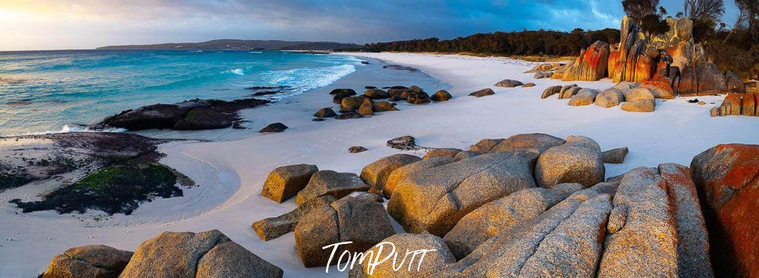 A beautiful landscape view of a seashore with white powder-like sand and some groups of random shaped stones are located in different areas, Cosy Corner Sunrise, Bay of Fires