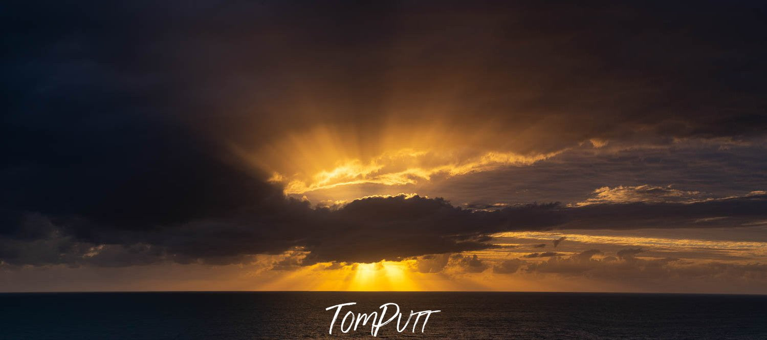 A dark view of approaching morning, the sun is hidden behind the heavy clouds, the yellowish effect of the sunlight is about to spread, Early Morning Sunburst, Far North Queensland