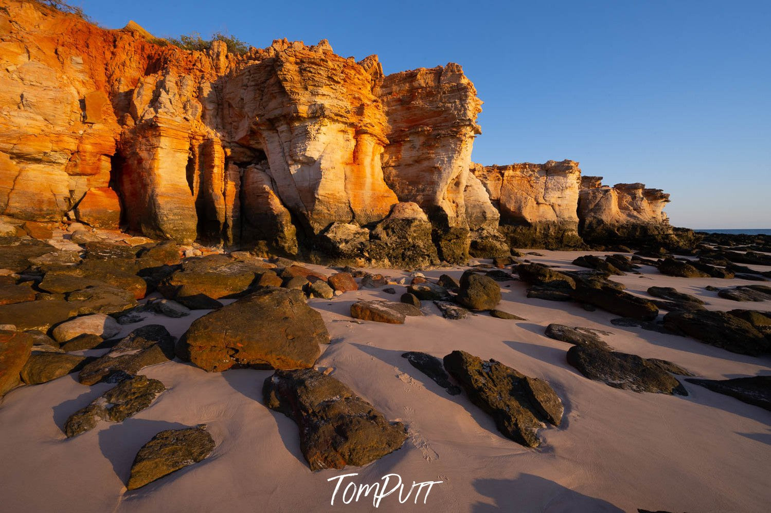 A long shiny mountain wall, a seashore land below the wall with a lots of small and large stones, Eastern Dawn, Cape Leveque, The Kimberley