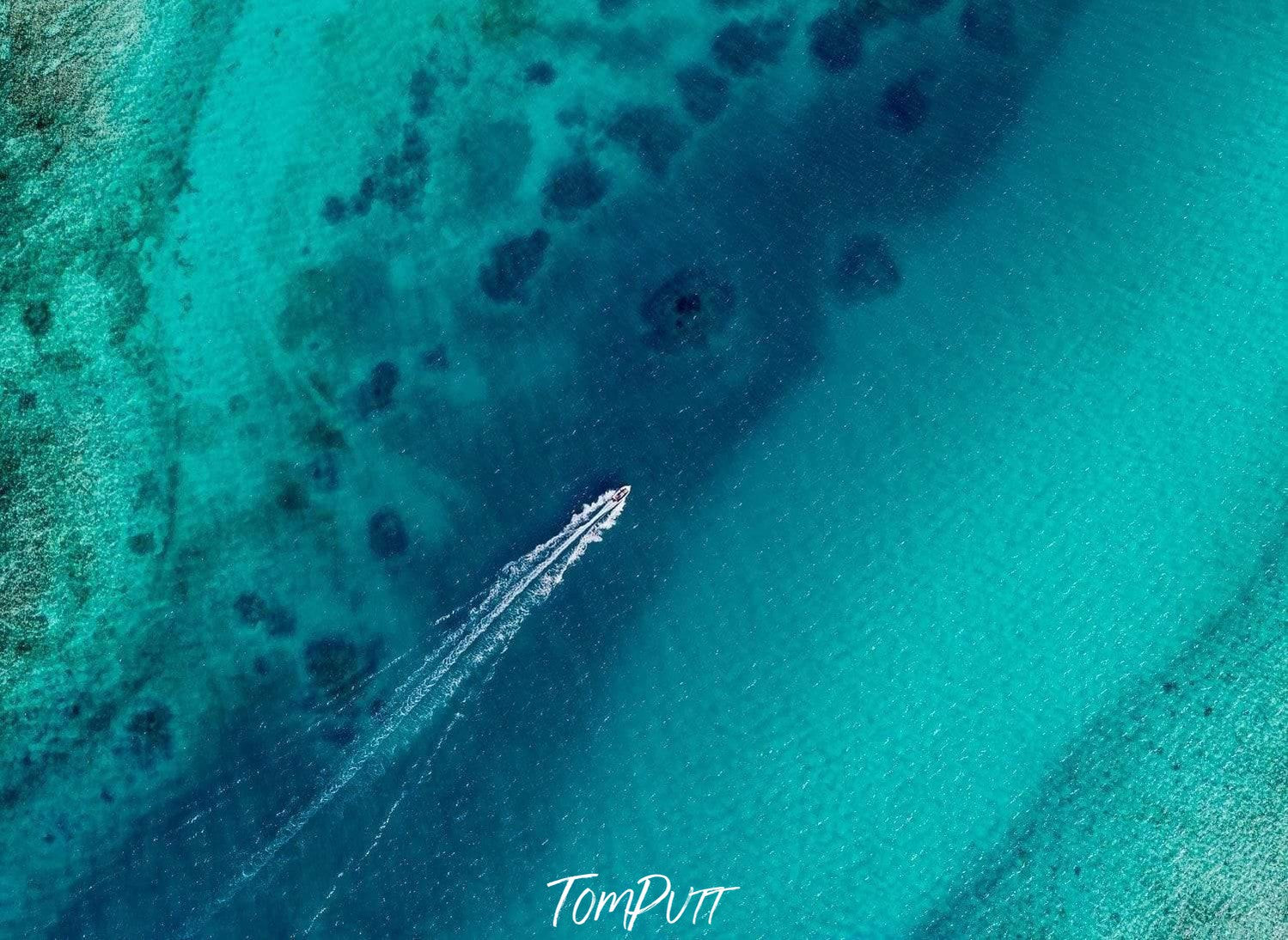 An aerial view of an ocean with only a boat floating over the surface of the water making a long mark on the surface, Escaping Houtman Abrolhos Artwork