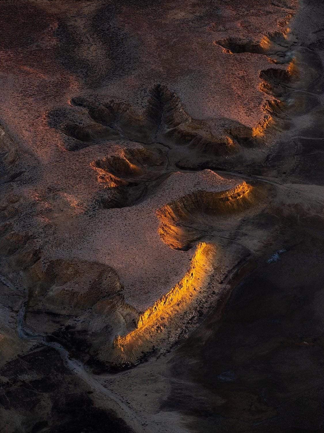 aerial view of a cut desert with wet sand and dark shadow effect, First Light