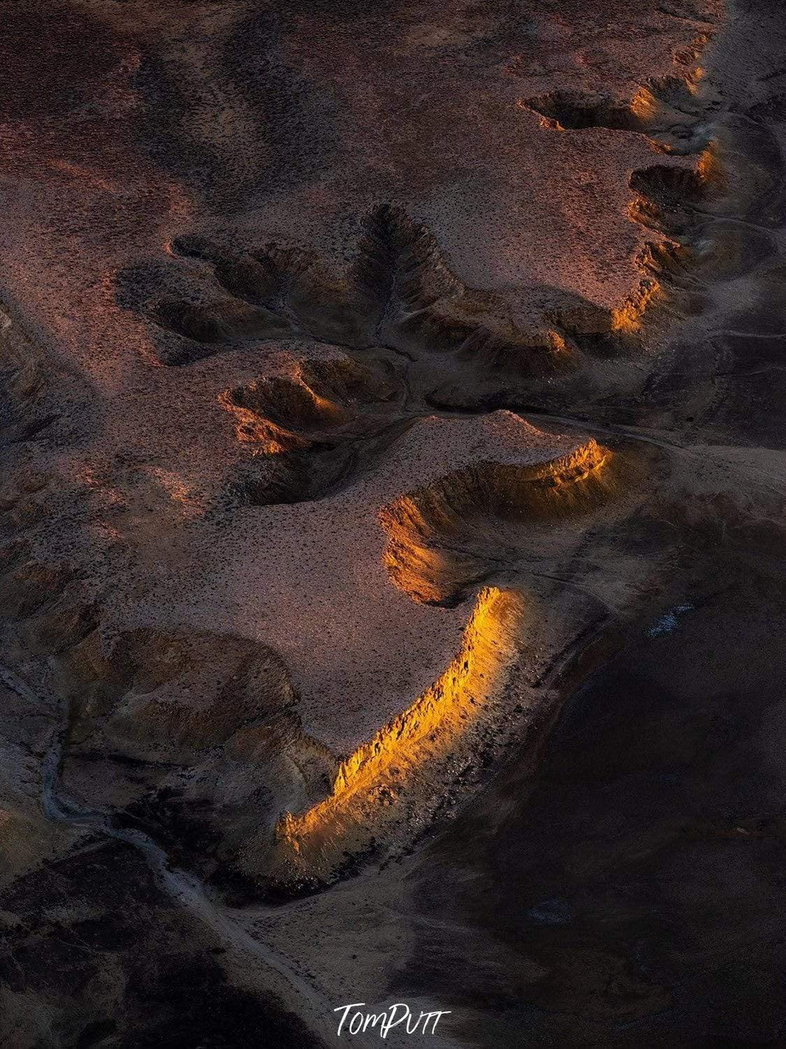 aerial view of a cut desert with wet sand and dark shadow effect, First Light
