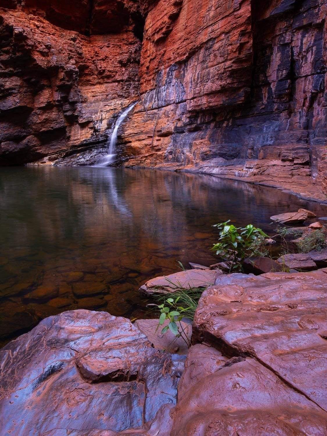 A small lake surrounded by mountain walls and stones, Handrail Tranquility - Karijini, The Pilbara