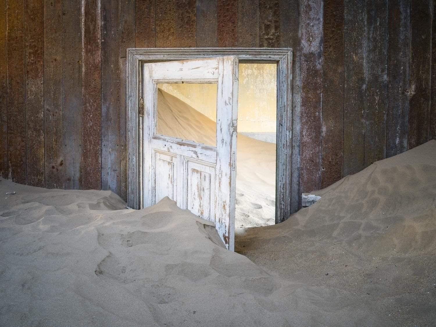 Making of a housing room with open door and a lot of construction sand, Kolmanskop #34