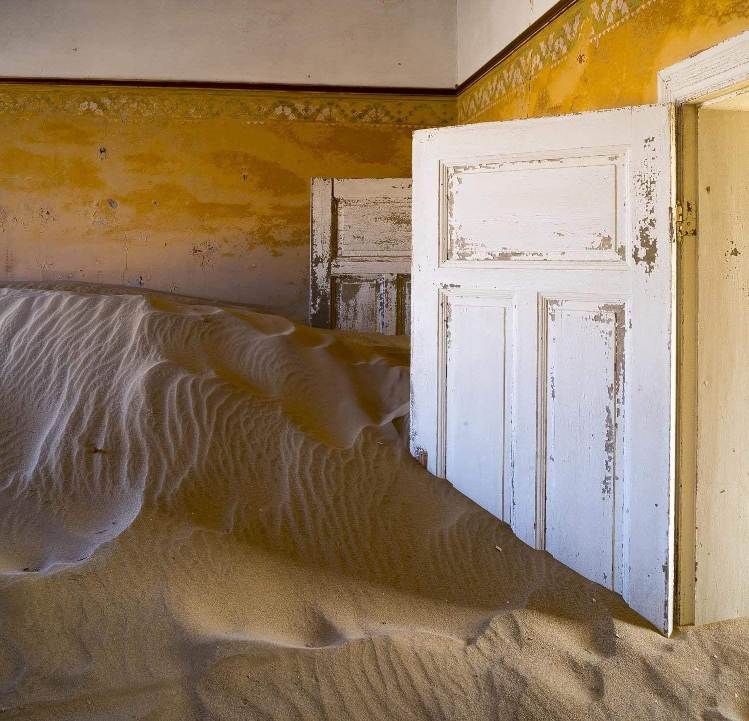 Making of a house with the open door of rooms, and a lot of construction sand inside, Kolmanskop #5