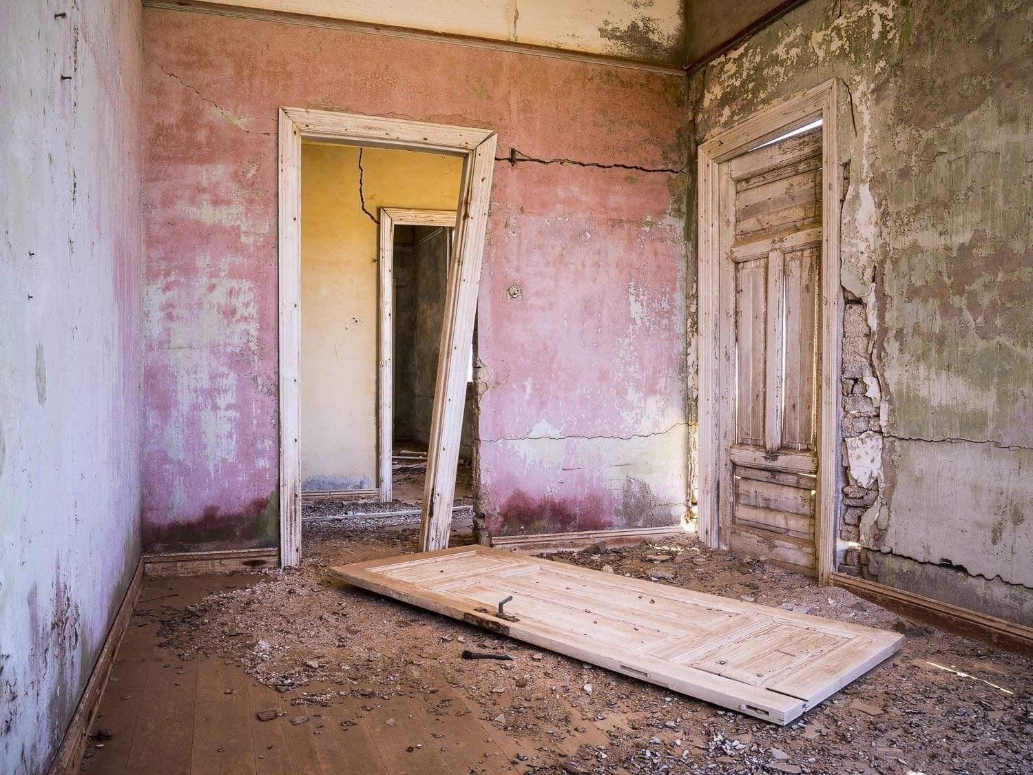 The broken door of a room of a constructing house, Kolmanskop #9
