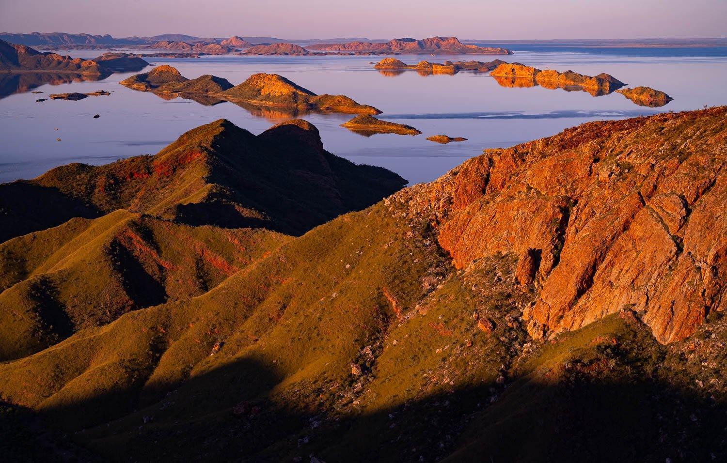 A giant couple of mountains with some greenery over them, and a lake in the background, Lake Argyle #4 - The Kimberley