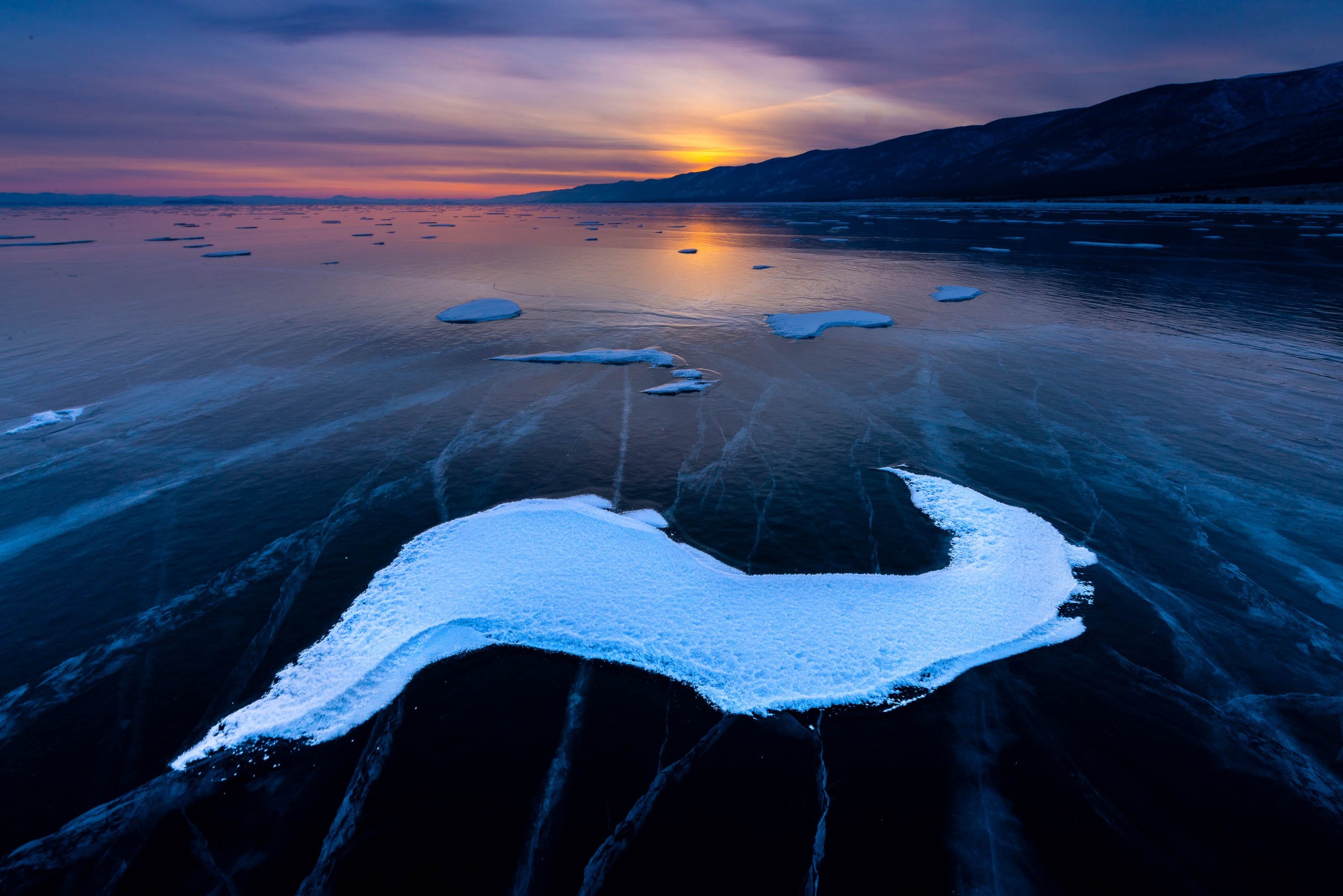 A frozen lake with some fresh snow, and a sunset effect in the background, Lake Baikal #32, Siberia, Russia