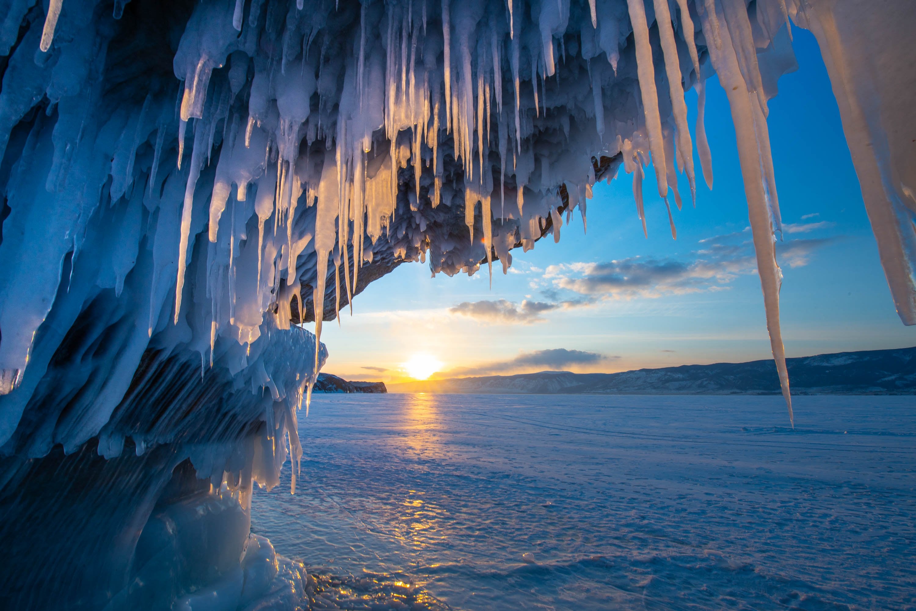 A beautiful frozen surface with some sharp crystalline ice sticks pointing down from a mountain wall, Lake Baikal #45, Siberia, Russia