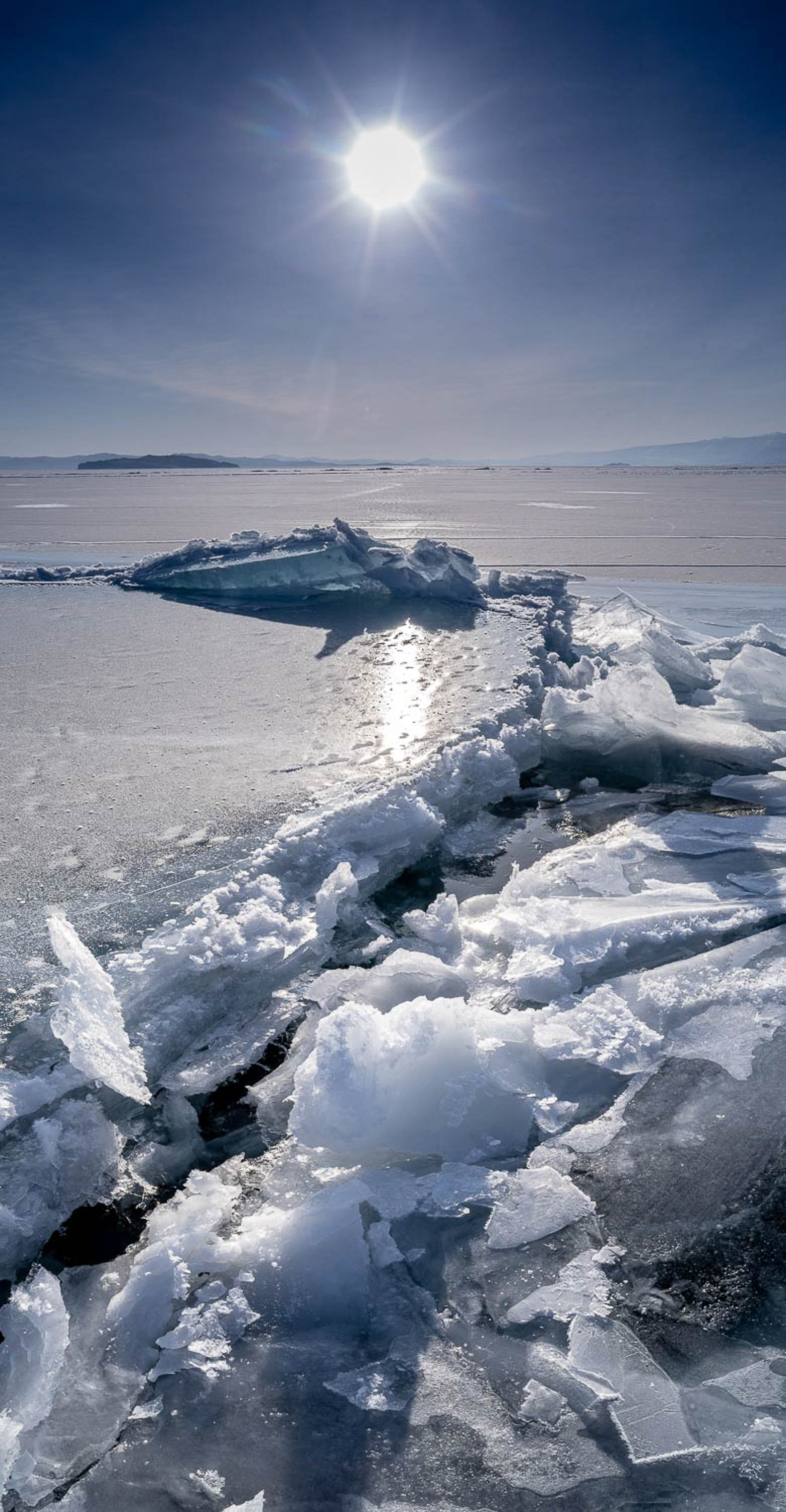 A thick and long crystalline ice line on a frozen surface, and the sun is shining, Lake Baikal #47, Siberia, Russia