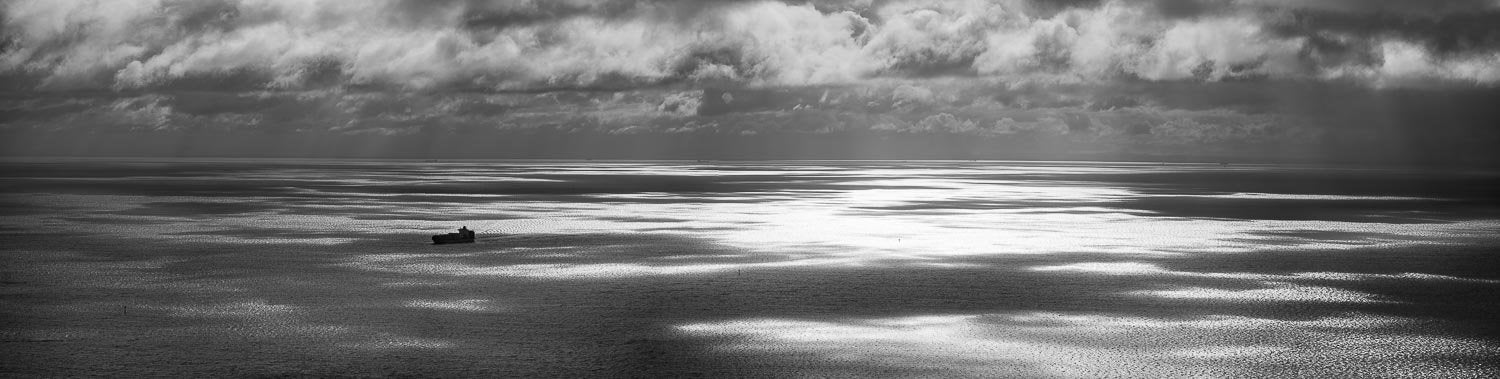Dark view of a lake with stormy mountains over, Light across Port Phillip Bay from Arthurs Seat - Mornington Peninsula, VIC