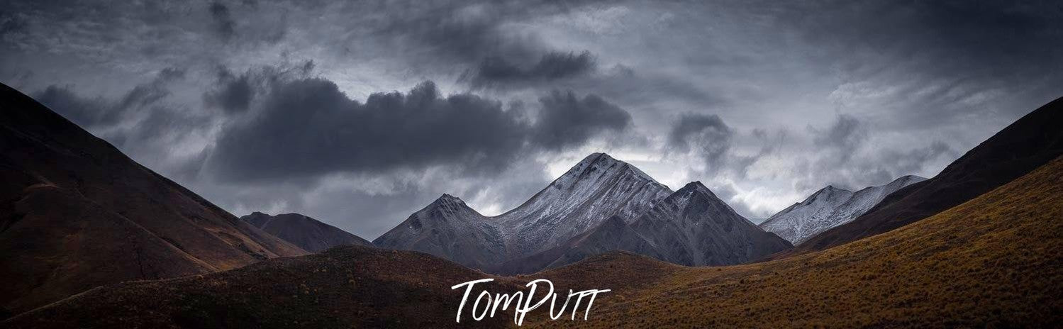 A long brown wall of mountains, and some black giant mountains in the far background, Lindis Pass New Zealand Artwork