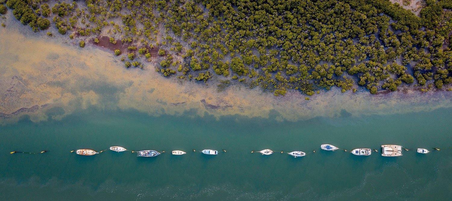 Aerial view of a beach with a line of many boats floating in a sequential manner, Lined Up, Warneet - Mornington Peninsula VIC 