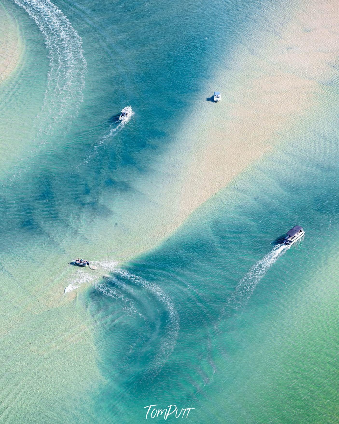 Aerial view of a shady lake with some boats running over, Noosa River