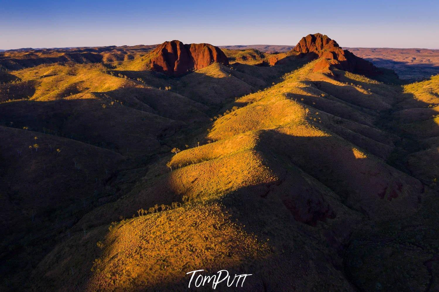 A long sequence of green mounds with sunlight falling over, Ragged Range #8, The Kimberley, Western Australia