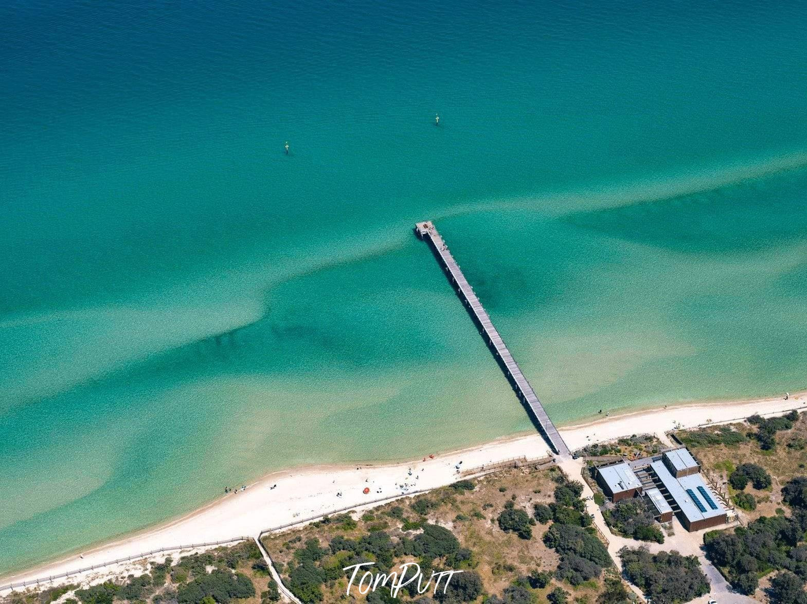 Aerial view of a seashore with a long and narrow bridge over, Seaford Pier from above, Mornington Peninsula, Victoria