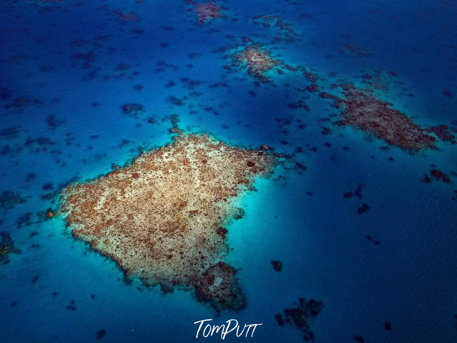 Aerial view of dark blue sea with a stony island, Spotlight