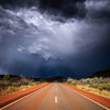Empty road following a dark dense group of clouds, Karijini Road - Karijini, The Pilbara