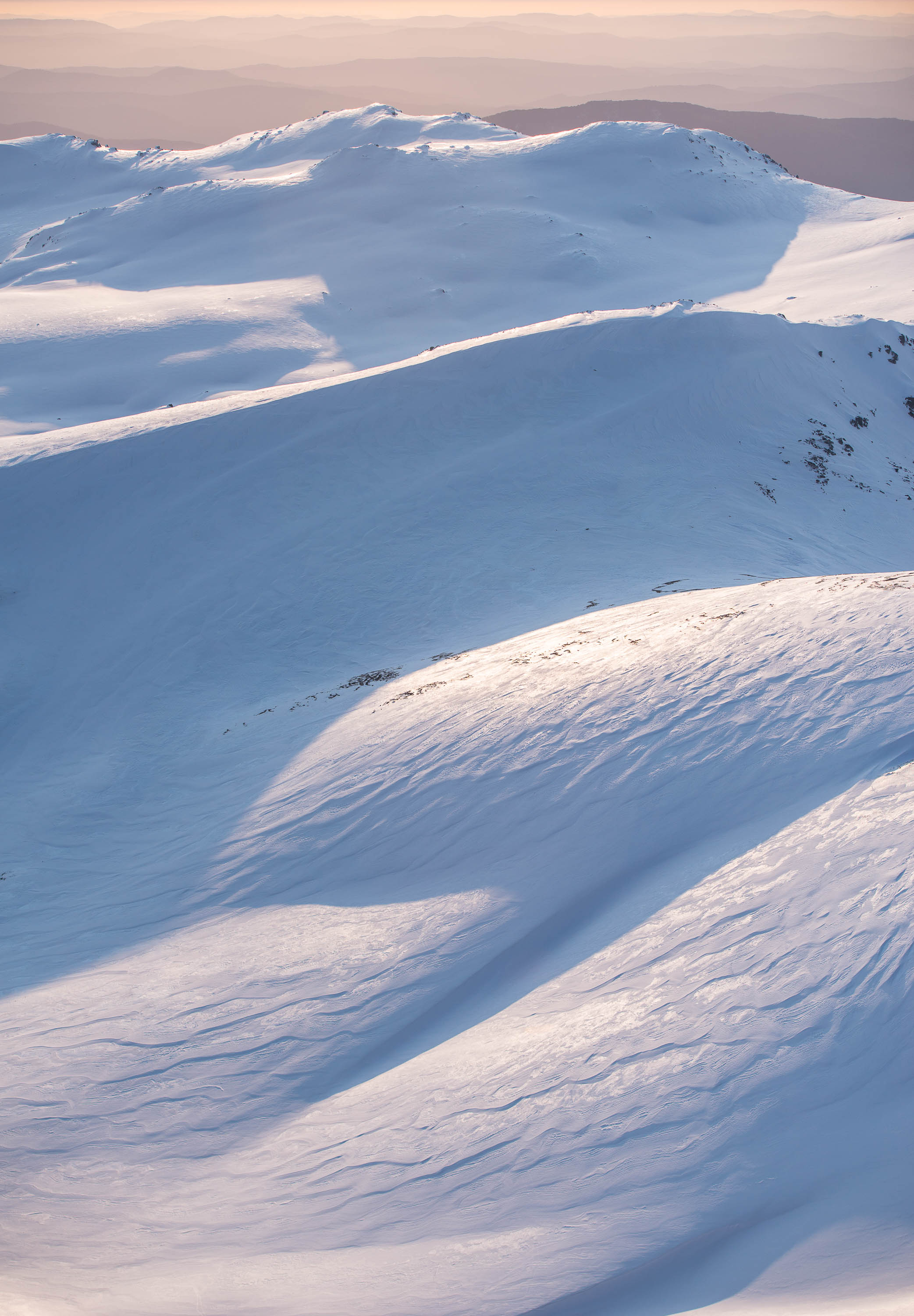 Aerial view of a snow-covered hill area with snow waves, Ridgelines, Snowy Mountains, New South Wales