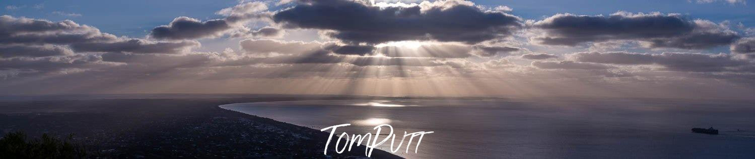 A landscape shot of the early morning, seashore with dense clouds over it and the Sun is rising, spreading the sunlight, Arthurs Seat Sunrays - Mornington Peninsula 