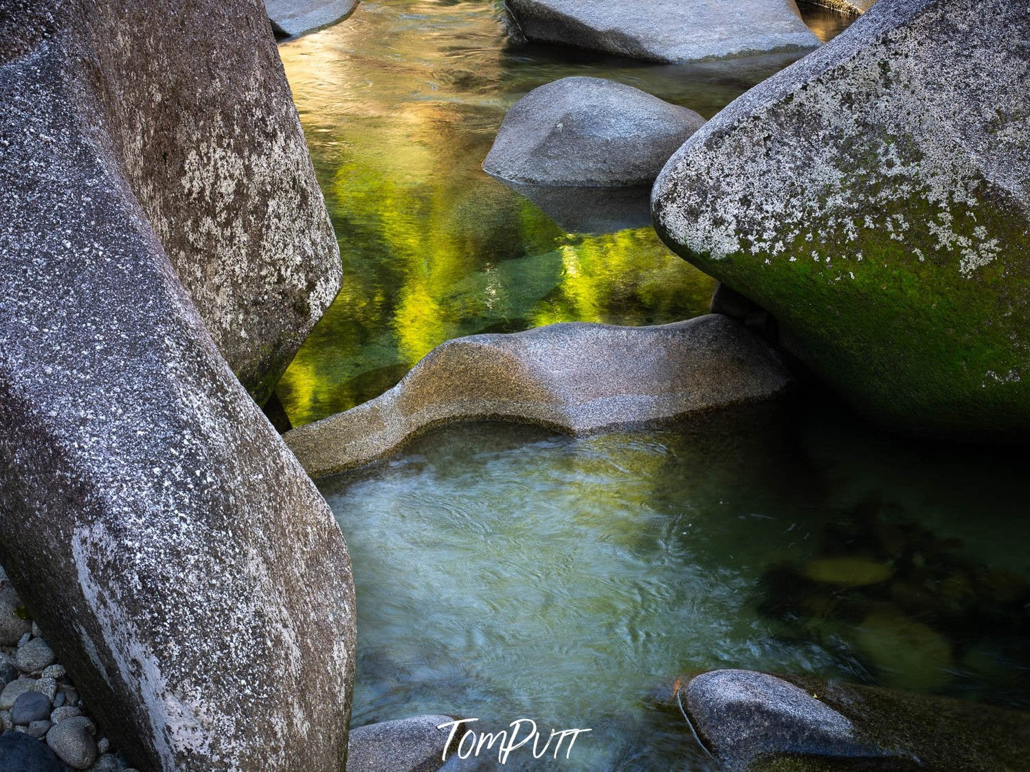 Giant grayish boulders in the lake causing a green ish reflection in the water, Babinda reflections, Far North Queensland