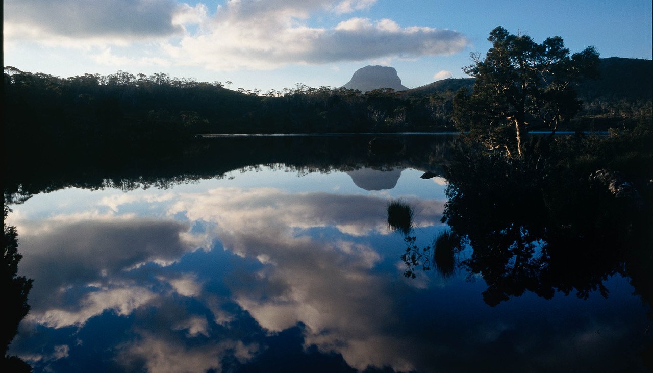 A lake surrounded by dark mountain walls, a reflection of sky in the water, Cradle Mountain #30, Tasmania 