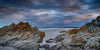 The weird shape of rocky stones on the sand of a seashore, stormy weather with dim daylight, Bay of Fires Panorama -  Tasmania 