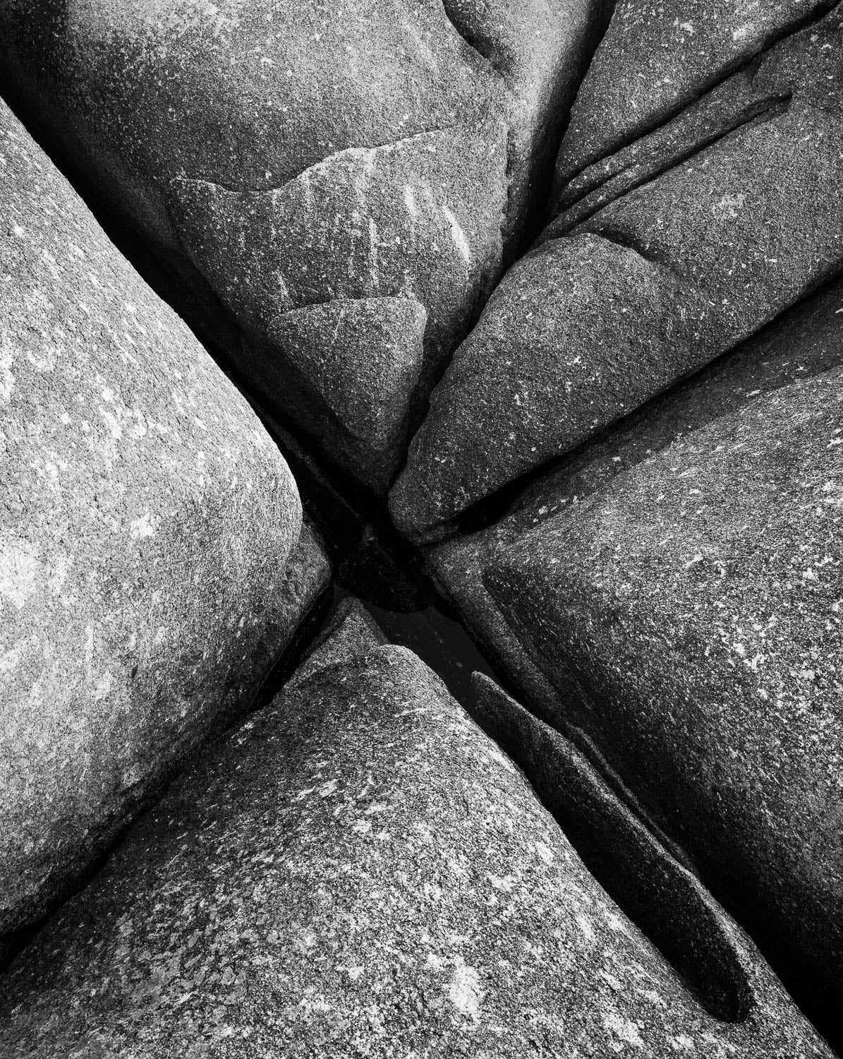 Parallel greyish-colored great boulders with some space in between, and some cracks in the topmost quadrant, Bay of Fires rocks grooves 