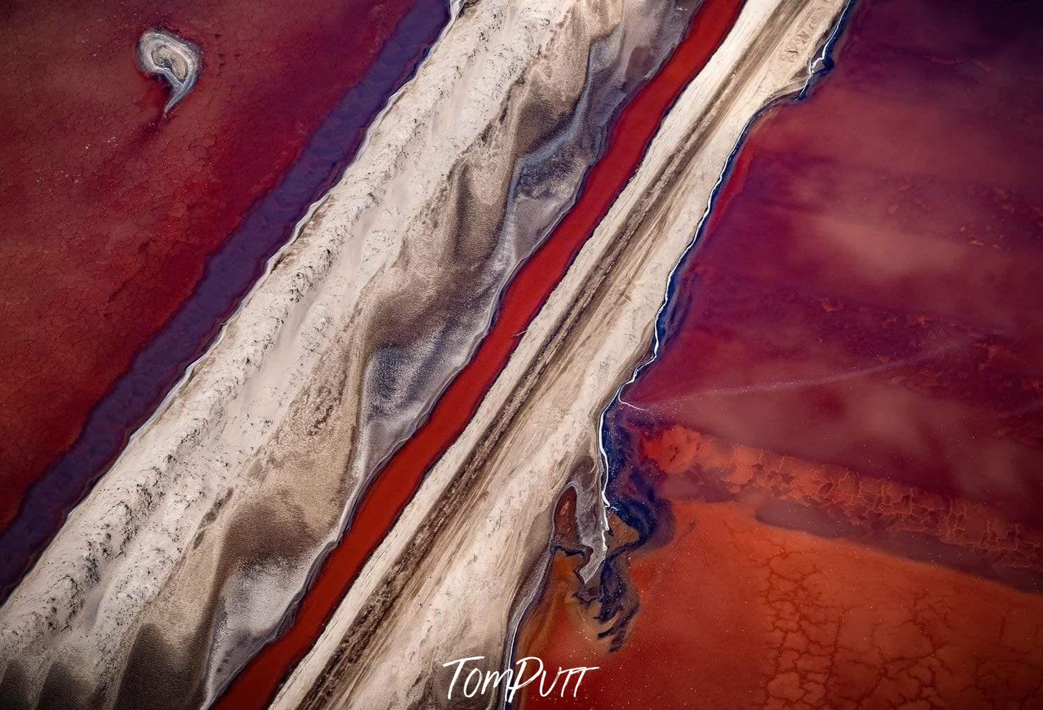 A weird Artwork of a dark red sea with two routes passing over it having a sand-like color, Blood Lines Namibia Art