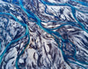 A breathtaking view of a large snow-covered area with thin lines of  flow of clear blue water, Blue Ribbon Iceland