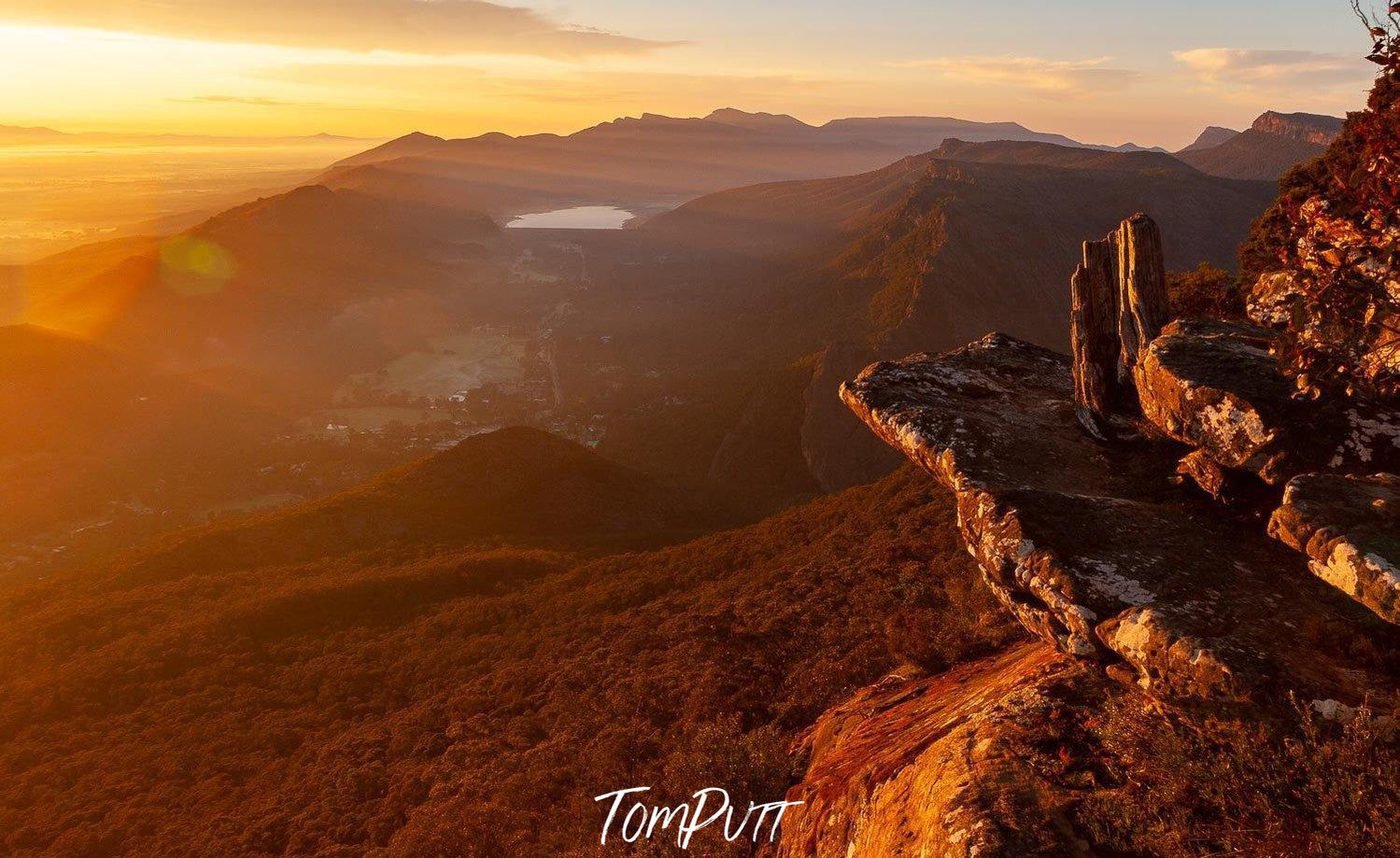 Giant Mountain stones on a high area with a huge grassy mound below them, and some other mountains and rocks in the background, a shiny effect of the sunlight is hitting the entire picture, Boroka Dawn - The Grampians, VIC 