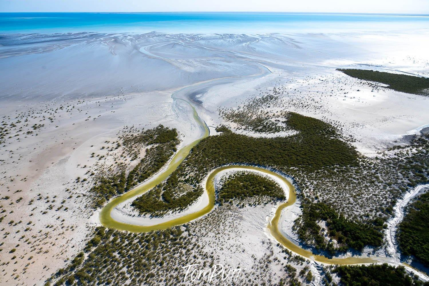 A morning view of a large land with a snake shape line of green color and a group of countless small trees some wet snow on the top and a sea in the far background, Broome No.23