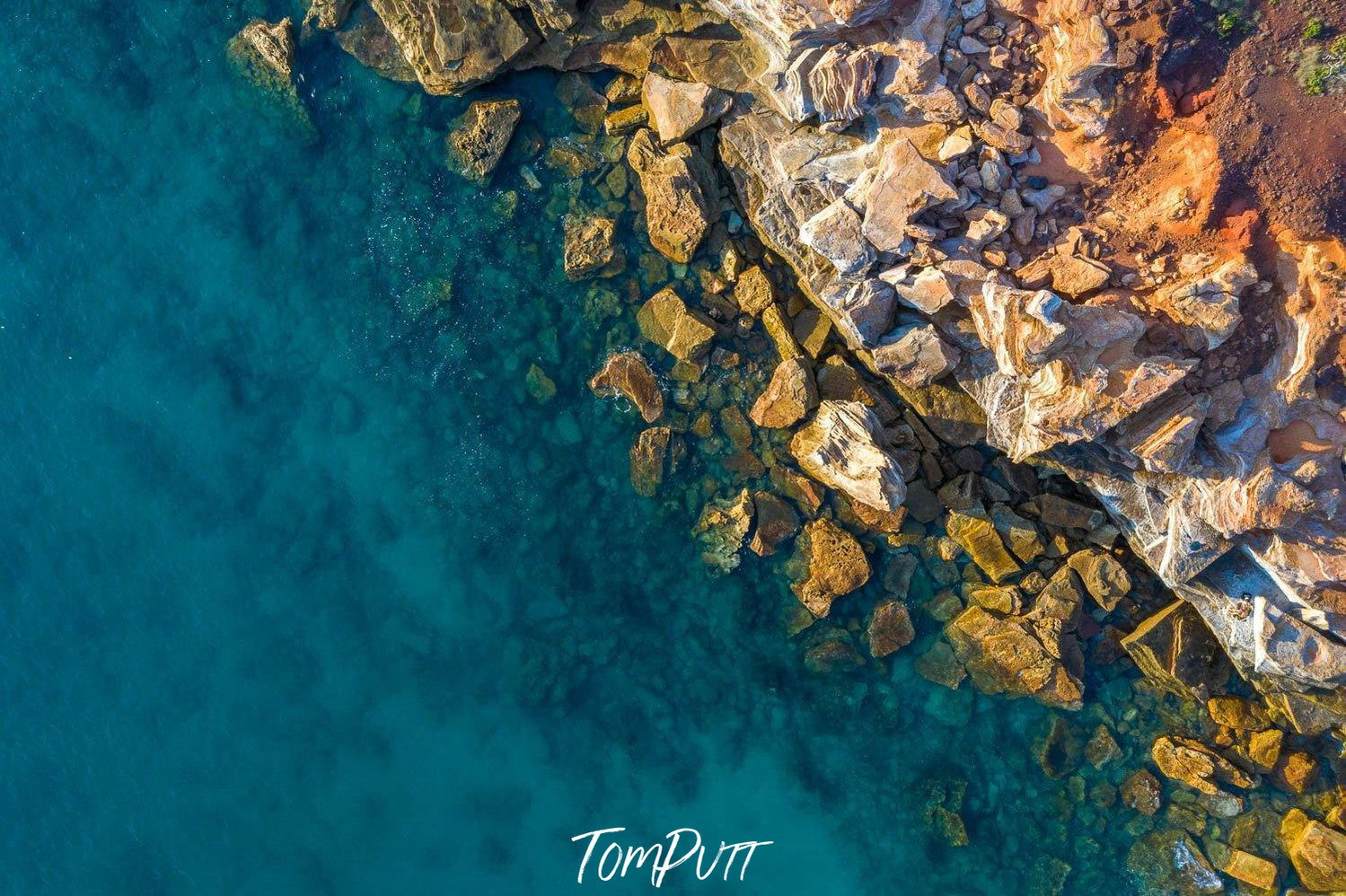 An aerial view of a lake corner with a lot of rocky stones, and an effect of the early sunlight falling on the scene, Broome No.28