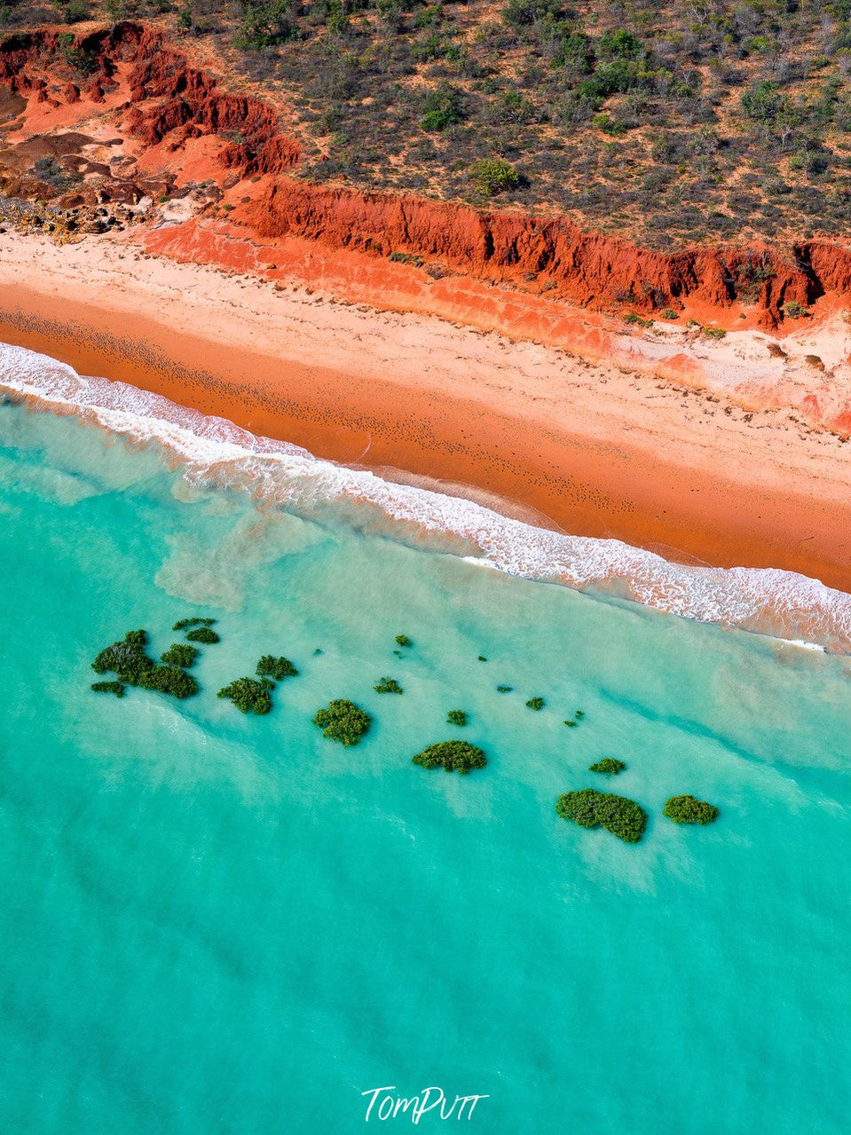 Aerial view of a seashore with orange-colored mountain wall with greenery over it, Broome No.38