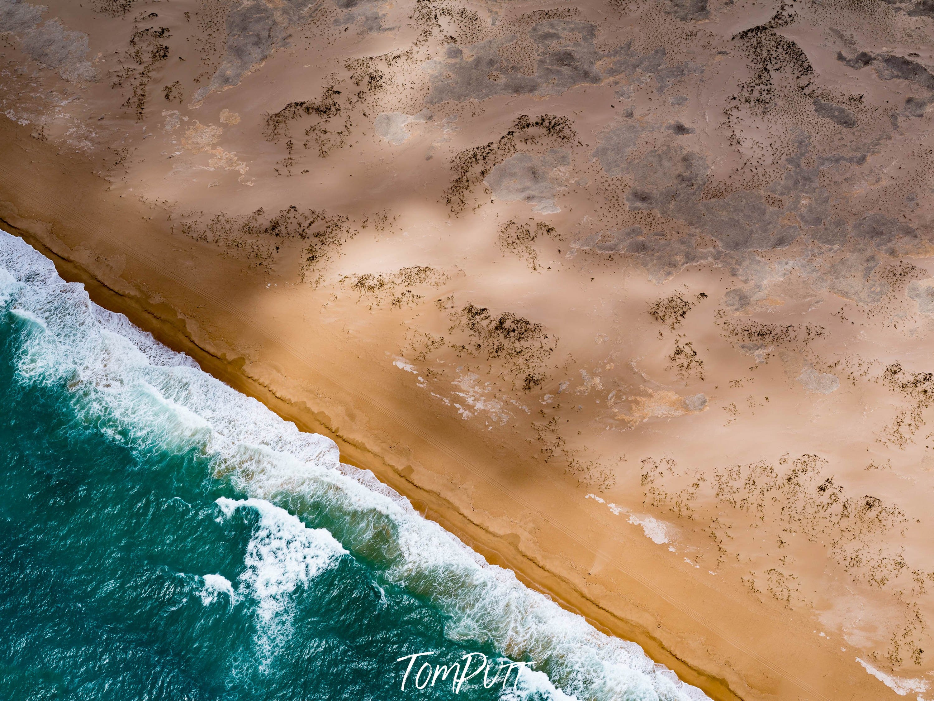 Aerial view of the green sea with bubbling waves connecting with desert, and partially hitting sunlight corner, Broome No.44