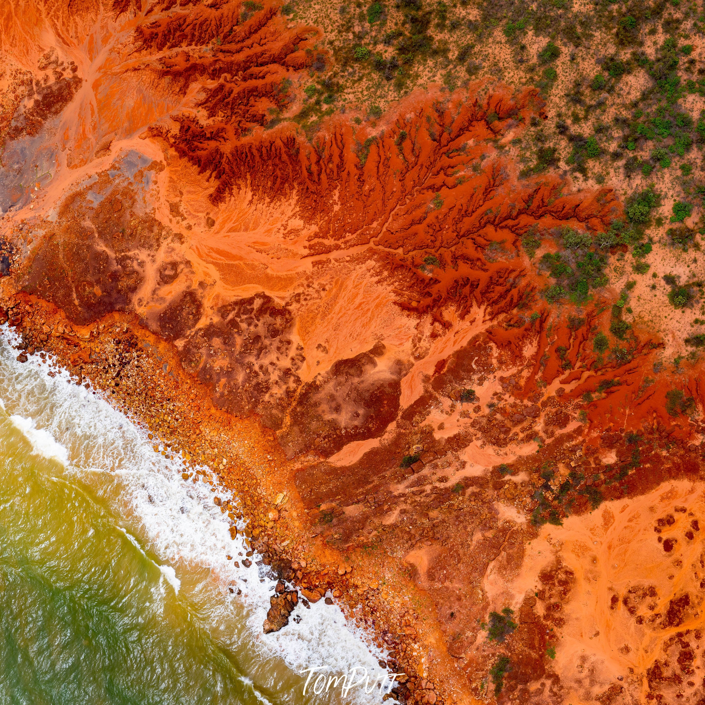 Aerial view of an orangish desert area connecting with the light green corner of the sea, Broome No.49