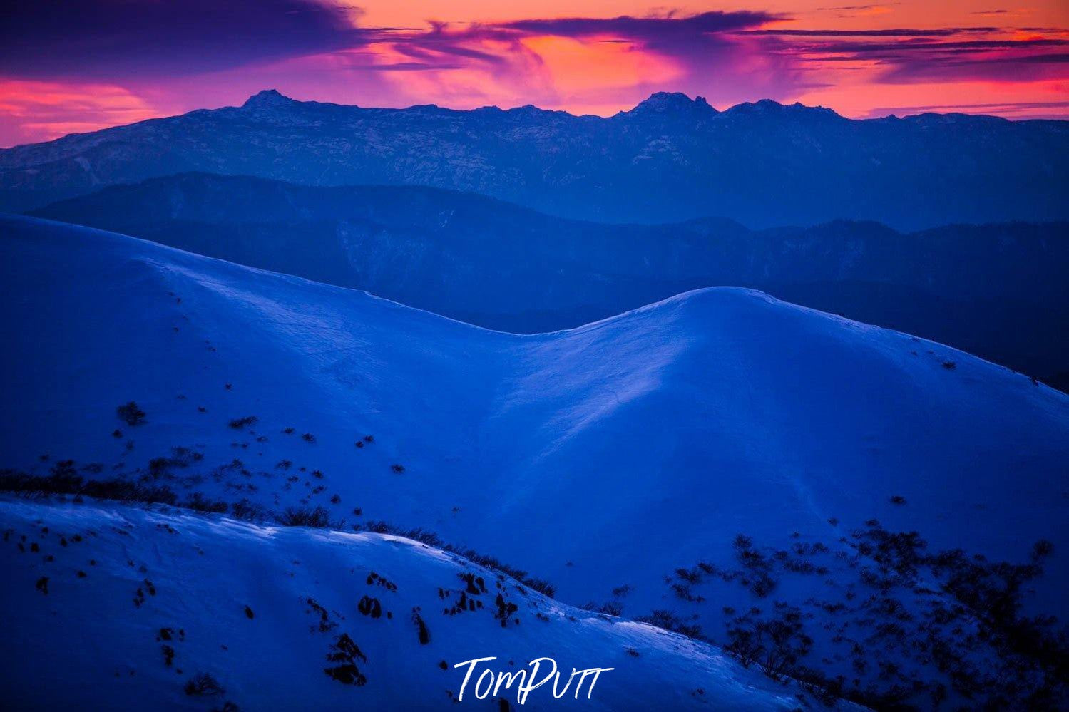 Giant mountains covered with snow forming a bluish shade, and a sunset effect in the background, Buffalo Plateau - Victorian High Country