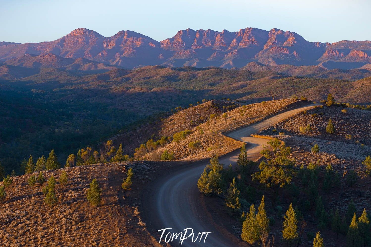 Long mountain walls with beautiful greenery on the land and mountains, a road following a wavy direction with some trees in the surroundings, Bunyeroo Valley, Flinders Ranges, South Australia