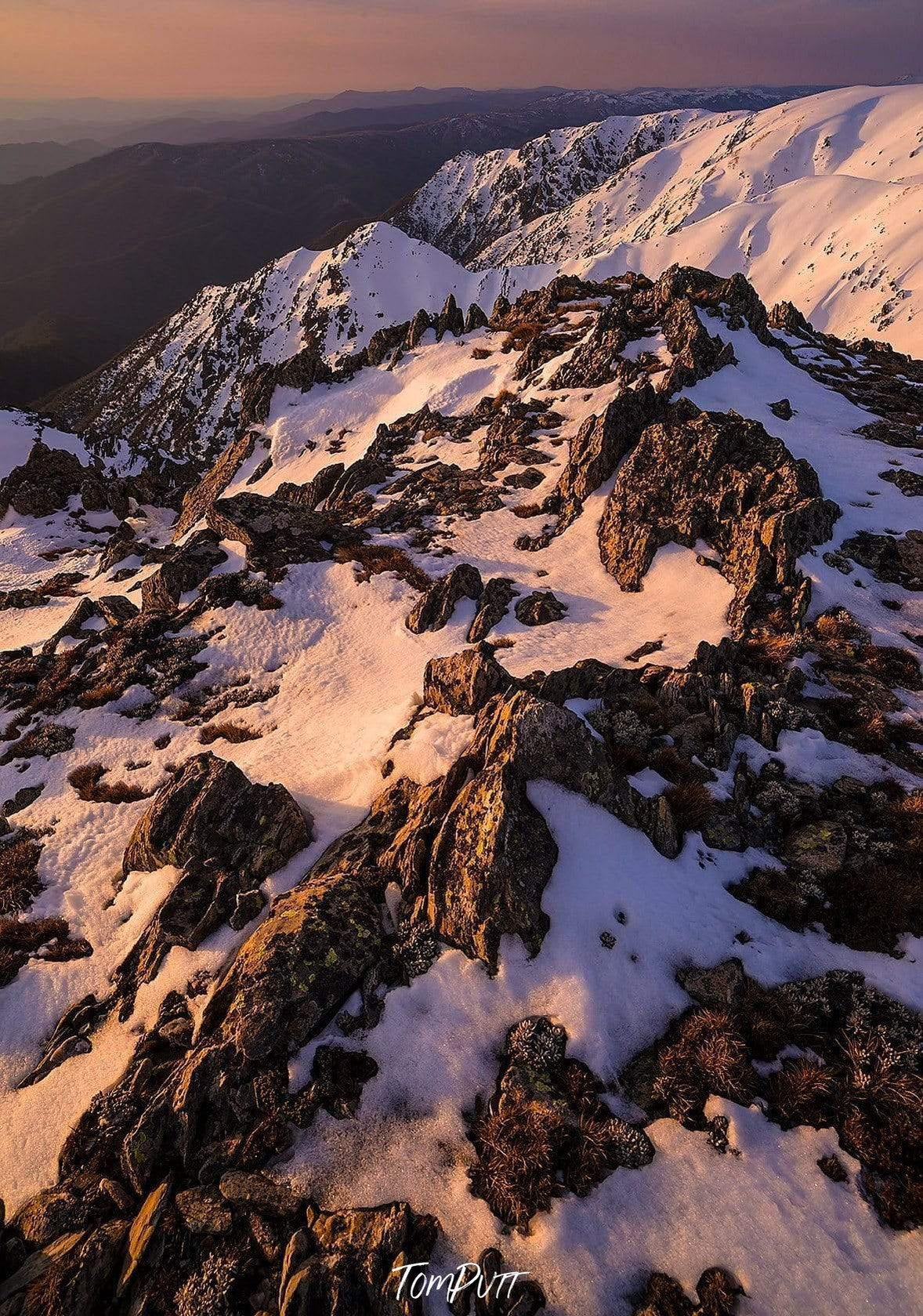 A giant mountain wall fully covered with fresh snow and some spots of wet sand on it, depicting a white ice-cream with chocolate chips on it, Carruthers Sunset - Snowy Mountains, NSW