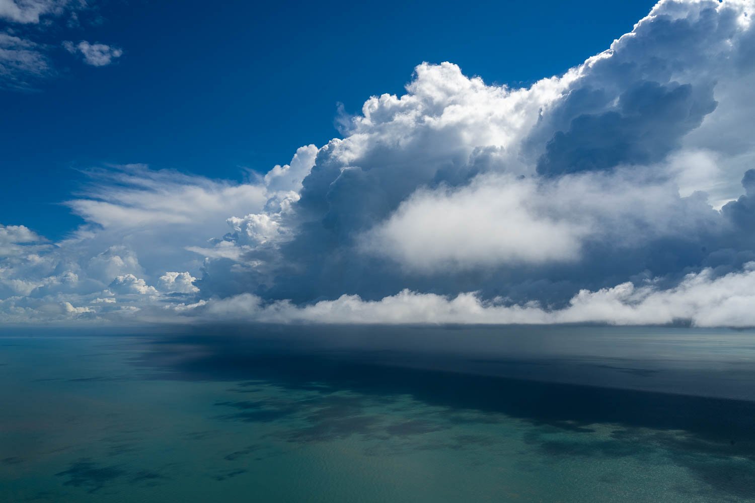 A giant smoky cloud just over the deep sea-green ocean stopping the shiny sunlight, Cloud Front, The Kimberley