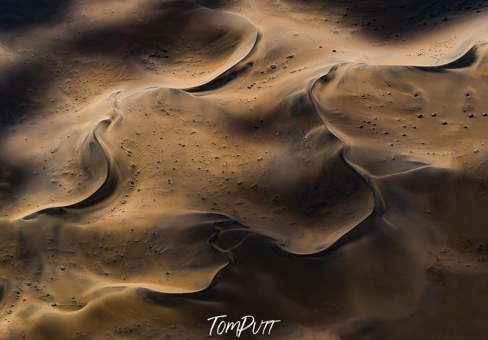 An artwork depicting alike a dense, shiny desert of chocolate-like sand forming the wavy shapes like a natural desert, Coming Together Artwork Print