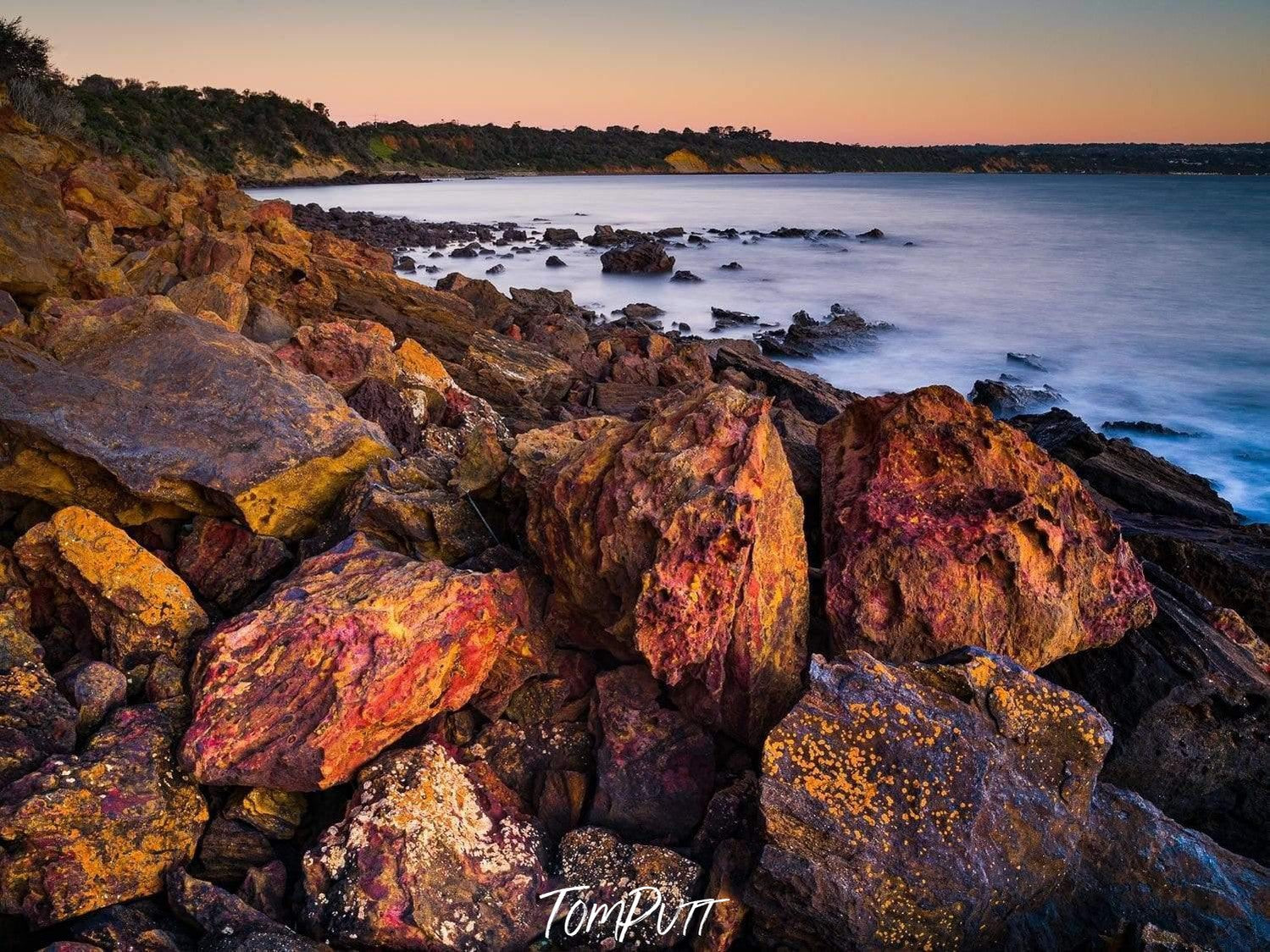 A closeup shot of rocky stones series with a natural texture and a seashore in the background, Coral Cove, Mt Martha - Mornington Peninsula Victoria