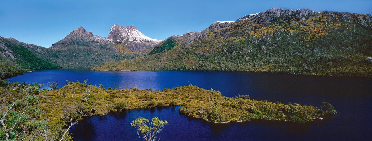A clear lake surrounded with green mountain walls, and some grassy area in the water, Cradle Mountain #38, Tasmania